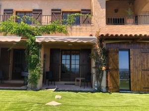 a building with a yard with a grass field at "Aux Balcons du Riou" avec vue mer 180 degrés in Vence