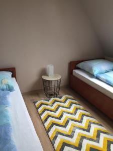 sypialnia z 2 łóżkami i dywanem na podłodze w obiekcie Domek AMPERO 2 we Władysławowie