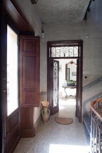 a hallway with a door and a table with a mirror at Appartamenti "Elegante & Romantico" in Trapani
