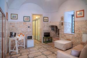 a living room with a couch and a table and a fireplace at Scuderie Maresca in Ostuni