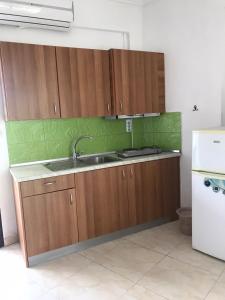 a kitchen with wooden cabinets and a sink at Vila Vergina in Pefkochori