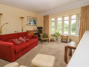 a living room with a red couch and a table at The Gables in York