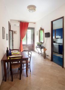 a dining room with a table and chairs and a kitchen at Appartamenti "Elegante & Romantico" in Trapani