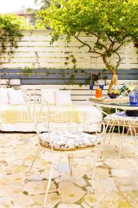 a patio with a table and two chairs and a table and a tree at Dimitra's Garden - Holiday Apartments in Parga