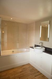 a bathroom with a sink and a bath tub at The Crown Inn in East Rudham