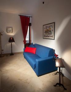 a blue couch with red pillows in a living room at Appartamenti "Elegante & Romantico" in Trapani
