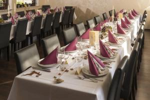 una fila de mesas con manteles rosados y blancos en Hotel Restaurant Häsfeld en Überherrn