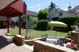 a patio with a table and an umbrella at Ferienwohnung Schwarzwaldliebe nahe Freiburg, Terrasse in Bollschweil
