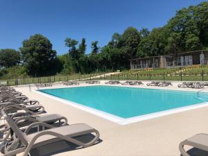 a large swimming pool with lounge chairs and a row at Agricamping Al grappolo diVino in Lazise