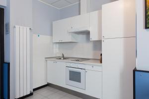 a white kitchen with a sink and a refrigerator at Hotel Tirreno in Genoa