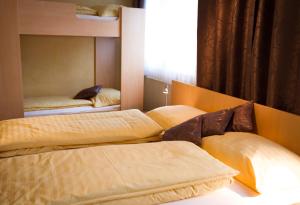 1 Schlafzimmer mit 2 Betten, einem Fenster und einem Bettvisor in der Unterkunft Gasthof Familie Hutter in Rattersdorf