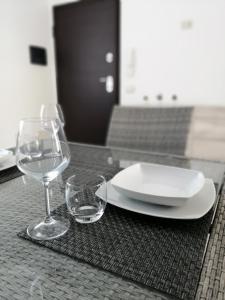 einen Tisch mit einem Teller und zwei Weingläsern in der Unterkunft Appartamento Monte Granatico 01 in SantʼAntìoco