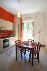 een keuken met een houten tafel en stoelen in een kamer bij Appartamenti "Elegante & Romantico" in Trapani