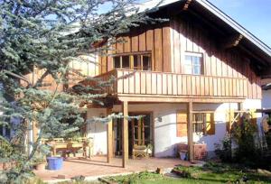 a large wooden house with a patio in front of it at My sweet home in Sauerlach