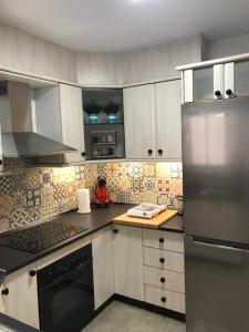 eine Küche mit weißen Schränken und Geräten aus Edelstahl in der Unterkunft Los Caños Home Águilas in Águilas