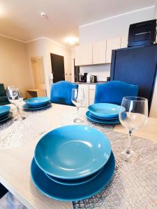 a table with blue plates and wine glasses on it at Apartament Dominikana in Sianozety