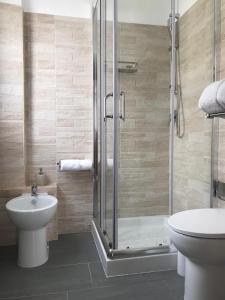 uma casa de banho com um chuveiro, um WC e um lavatório. em Bella Posada B&B em Buggerru