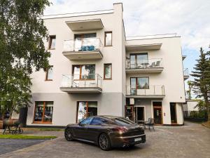 a black car parked in front of a building at Apartament Dominikana in Sianozety