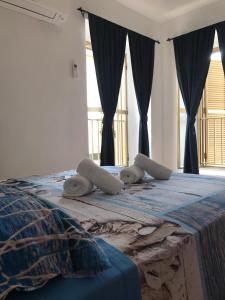 una camera da letto con letto con lenzuola e finestre blu di Bella Posada B&B a Buggerru