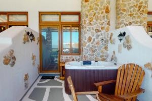 a bathroom with a tub and a wooden chair at Limeri Traditional Guest House in Monólithos