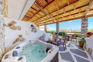 a hot tub on a patio with a table and chairs at Limeri Traditional Guest House in Monólithos