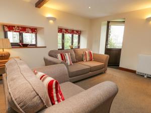 a living room with two couches and a tv at Woodside Barn in Ulverston