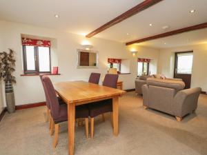 a dining room with a wooden table and chairs at Woodside Barn in Ulverston