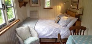 アバーガベニーにあるCaban Bryn Arwの小さなベッドルーム(ベッド1台、椅子付)