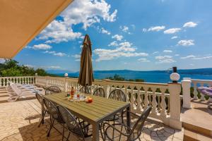 a patio with a table and an umbrella at House Villa Andrea in Crikvenica