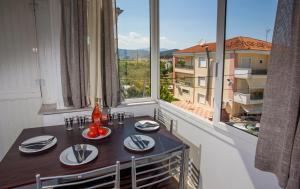 a table and chairs in a room with a large window at Ammos Studios & Apartments in Nea Peramos
