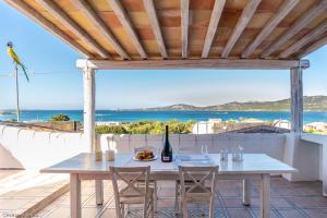 a table on the balcony with a view of the ocean at Case Vacanze La Conia in Cannigione