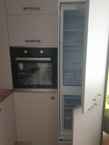 a kitchen with an empty refrigerator and an oven at Body Residence in Mamaia Nord