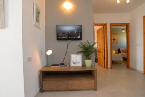 uma sala de estar com uma mesa e uma televisão na parede em Seaside Apartments Malta Sliema 1 em Sliema