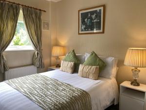 een slaapkamer met een bed met 2 lampen en een raam bij copperfield house in Cashel