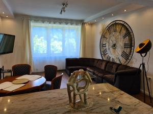 a living room with a large clock on the wall at Felsenburgapartment in Hermagor