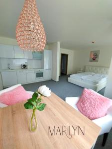 een woonkamer met een houten tafel en een slaapkamer bij THE MEETINKA apartments in Jeseník