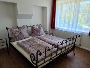a bedroom with a black bed with pink blankets and pillows at Felsenburgapartment in Hermagor