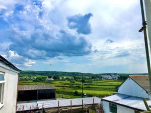 a view of a field and a cloudy sky at Pendrin Guest House in Tintagel