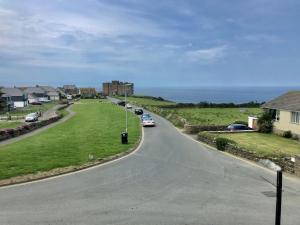 una carretera sinuoso con coches estacionados a un lado de la carretera en Pendrin Guest House en Tintagel