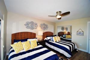 a bedroom with two beds with blue and yellow pillows at Ocean Vista Condo Unit #1201 in South Padre Island +32 photos
