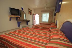 a row of beds in a hotel room at Hotel Xestal in Santa Cruz Huatulco