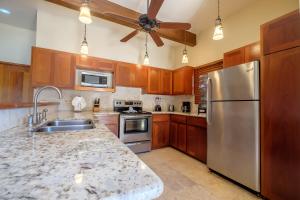 a kitchen with wooden cabinets and a stainless steel refrigerator at Three-Bedroom Apartment in San Pedro