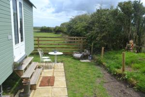 a backyard with a table and chairs and a fence at Peaceful Shepherd's Hut next to Horse Field in Morpeth +13 photos