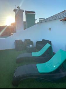 a group of green shoes on the side of a house at quarto suite em Belém in Lisbon