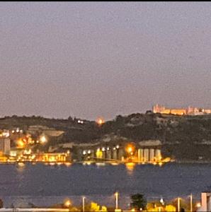 a night view of a city and the water at quarto suite em Belém in Lisbon