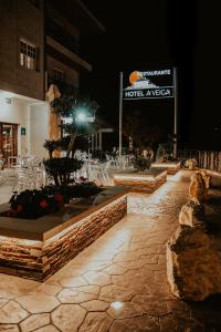 eine Terrasse in einem Hotel in der Nacht mit Tischen und Stühlen in der Unterkunft Hotel A Veiga in Samos