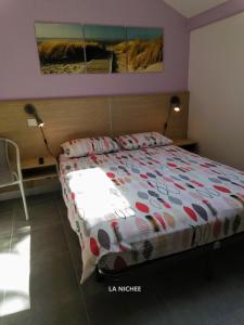een slaapkamer met een groot bed met 2 lampen bij la Nichée in Hauteville-Lompnes