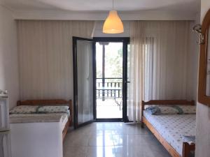 a room with two beds and a door to a balcony at Vila Vergina in Pefkochori