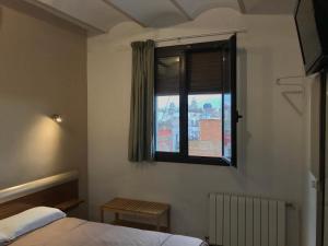 a bedroom with a bed and a window at Hostal Radio Barcelona in Barcelona