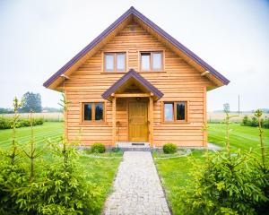 una casa de madera con una puerta en un campo en Kraina Dauby, en Wielowieś